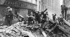 Kids climb rubble and collect scraps in front of a seized manufacturing property