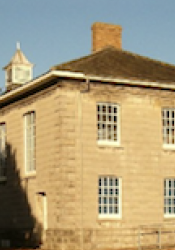 Photograph of the facade of a two-storey brick building with casement windows