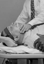 A patient is shown being strapped into an electroshock therapy table.